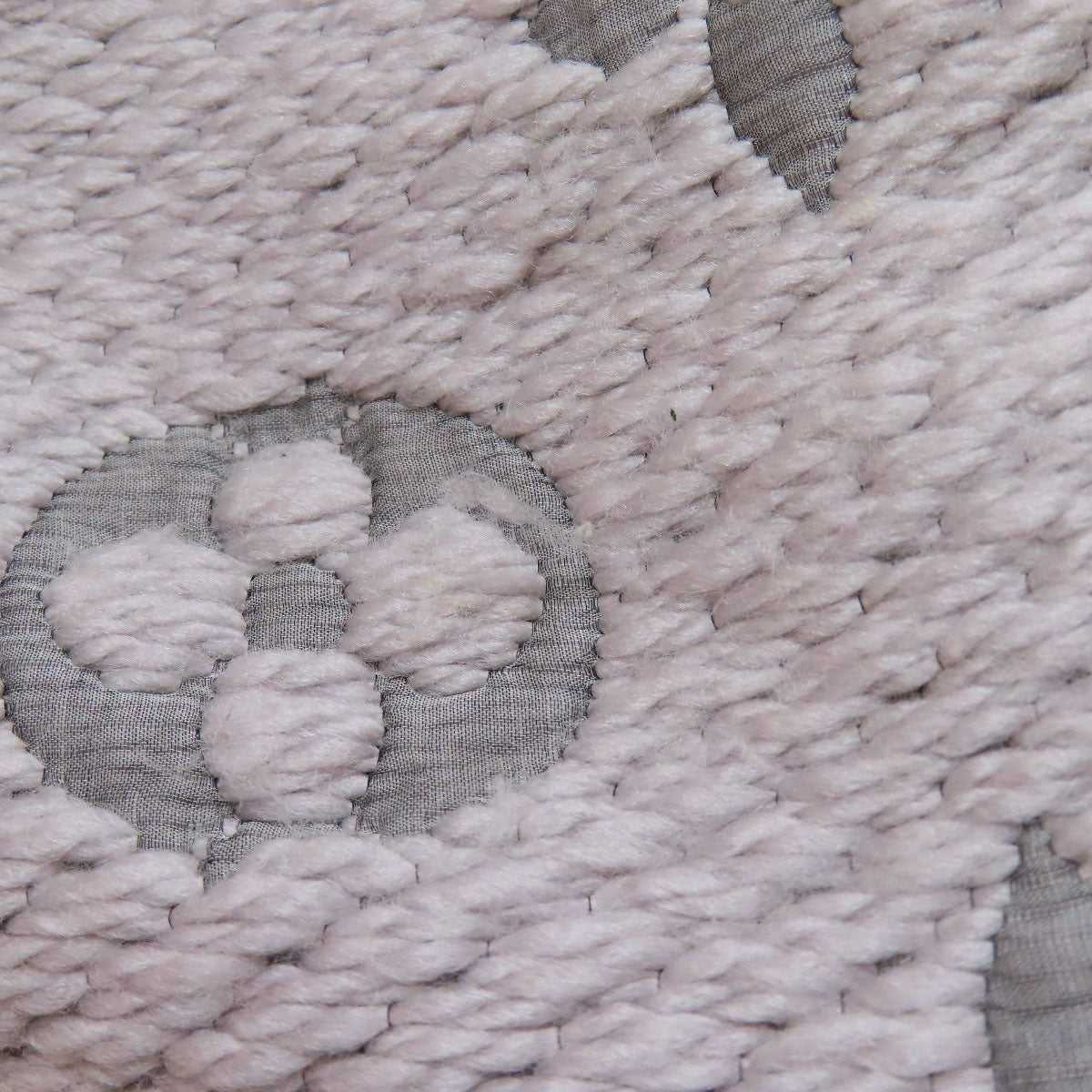 Close-up of pre-owned Louis Vuitton wool scarf featuring iconic patterns and soft texture