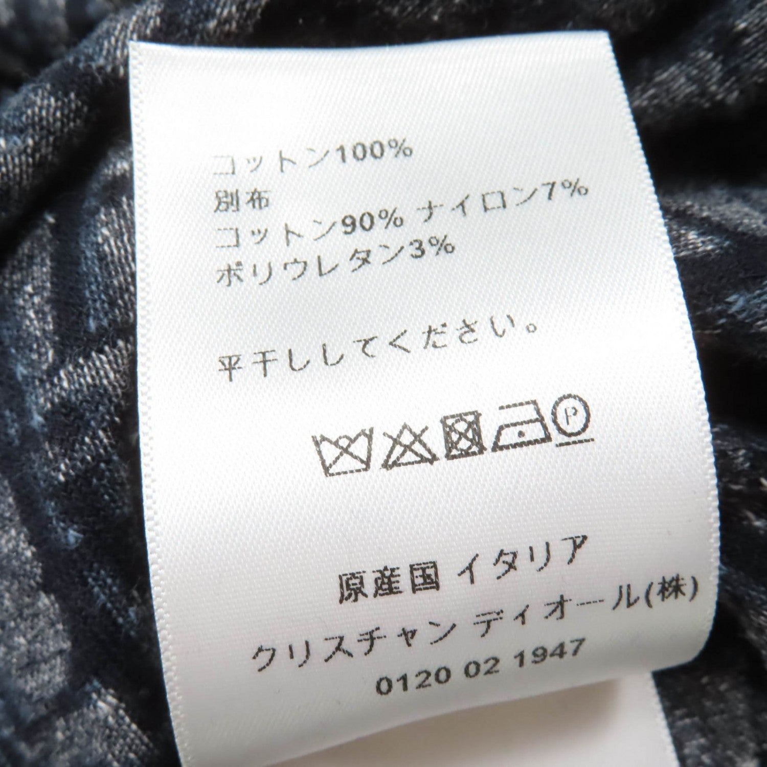 Care label on luxury secondhand Dior womenswear displaying fabric composition and washing instructions
