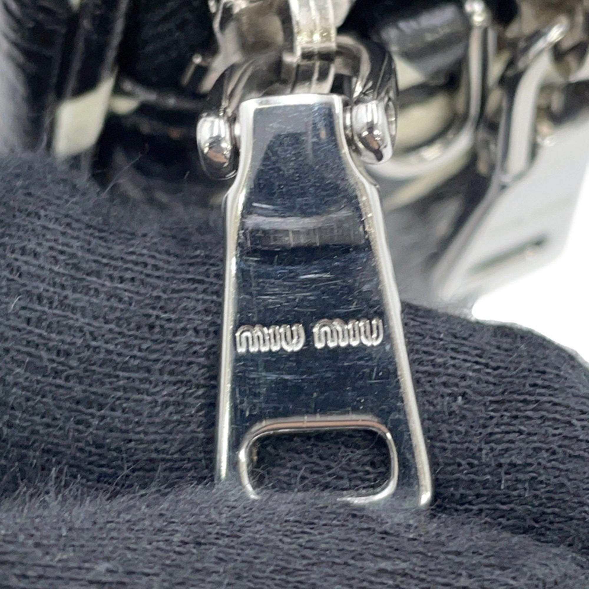 Close-up of MIU MIU Pre-Loved Swallow Pattern Bag zipper detail showcasing the logo and craftsmanship