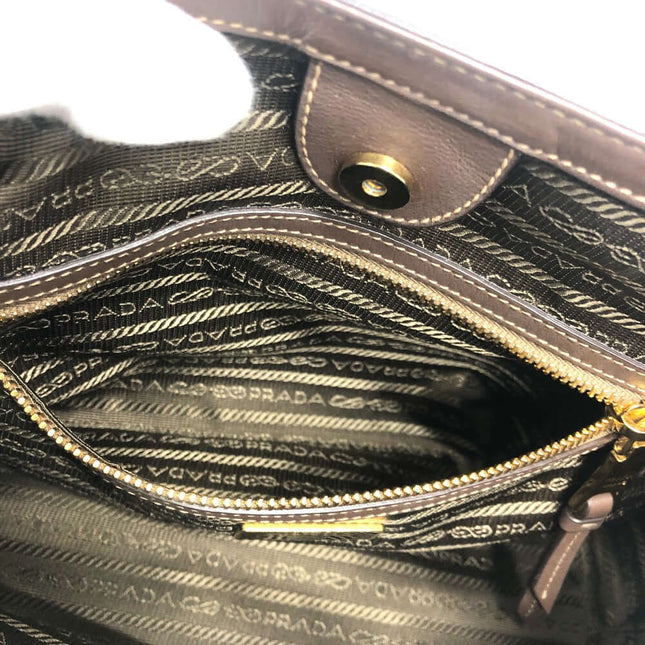 Interior view of PRADA pre-owned bag featuring signature lining and multiple pockets