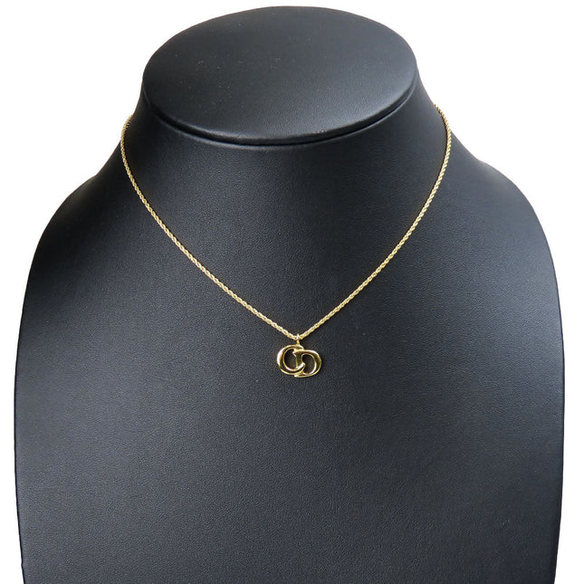 Pre-loved Christian Dior gold chain necklace with iconic logo pendant on a display bust