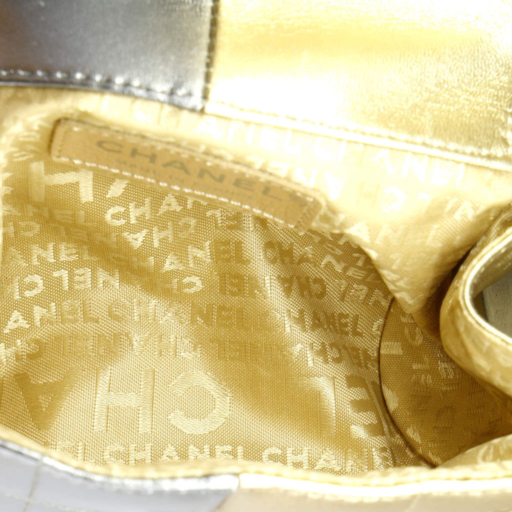 Interior view of a pre-owned CHANEL wristlet bag showcasing elegant gold lining and logo pattern