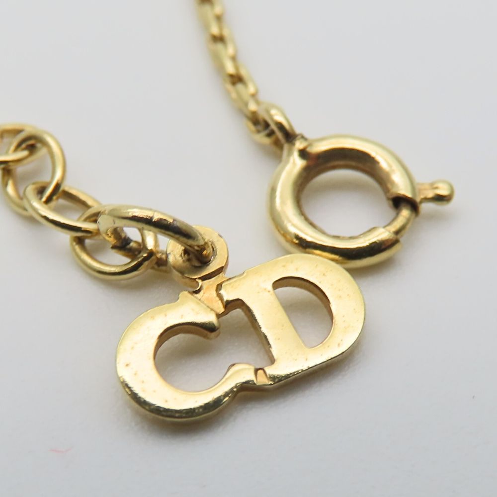 Close-up of a clasp on a pre-owned Christian Dior gold necklace with a distinctive CD logo