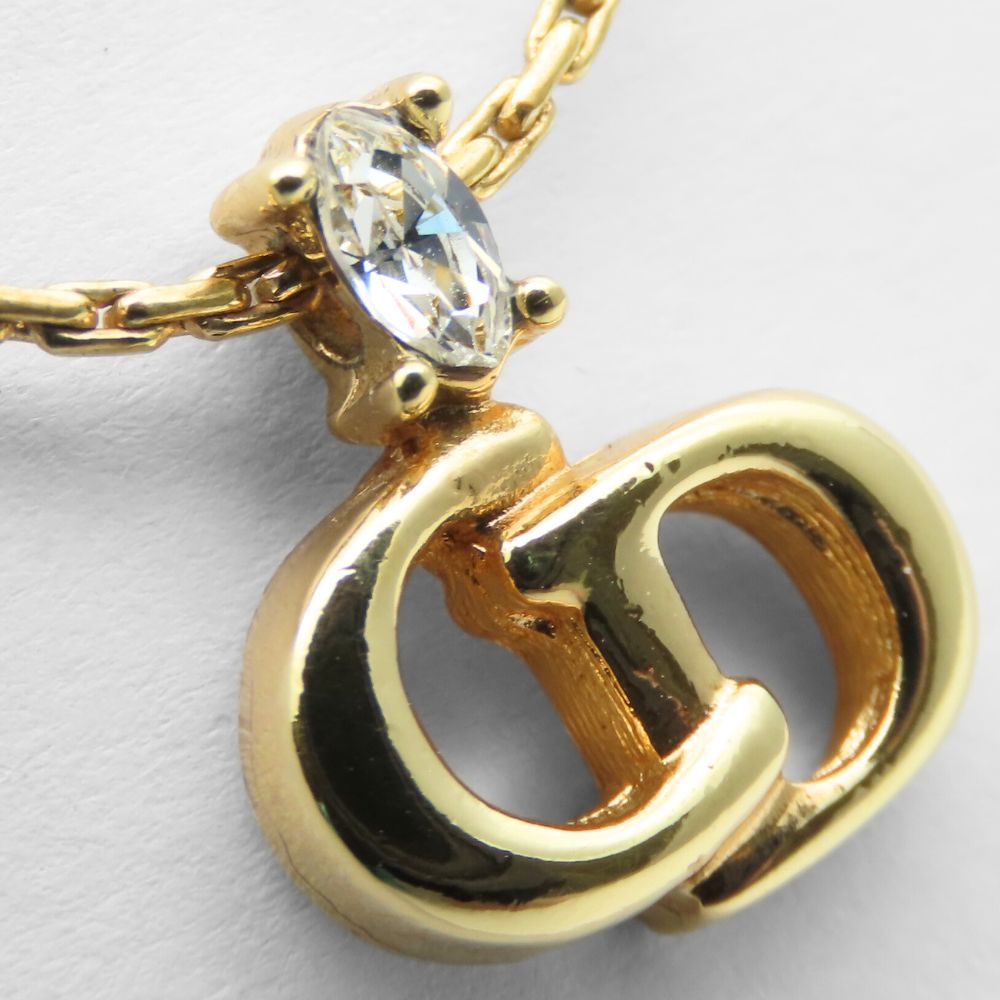 Close-up of a pre-owned Christian Dior gold necklace featuring a diamond accent and iconic logo