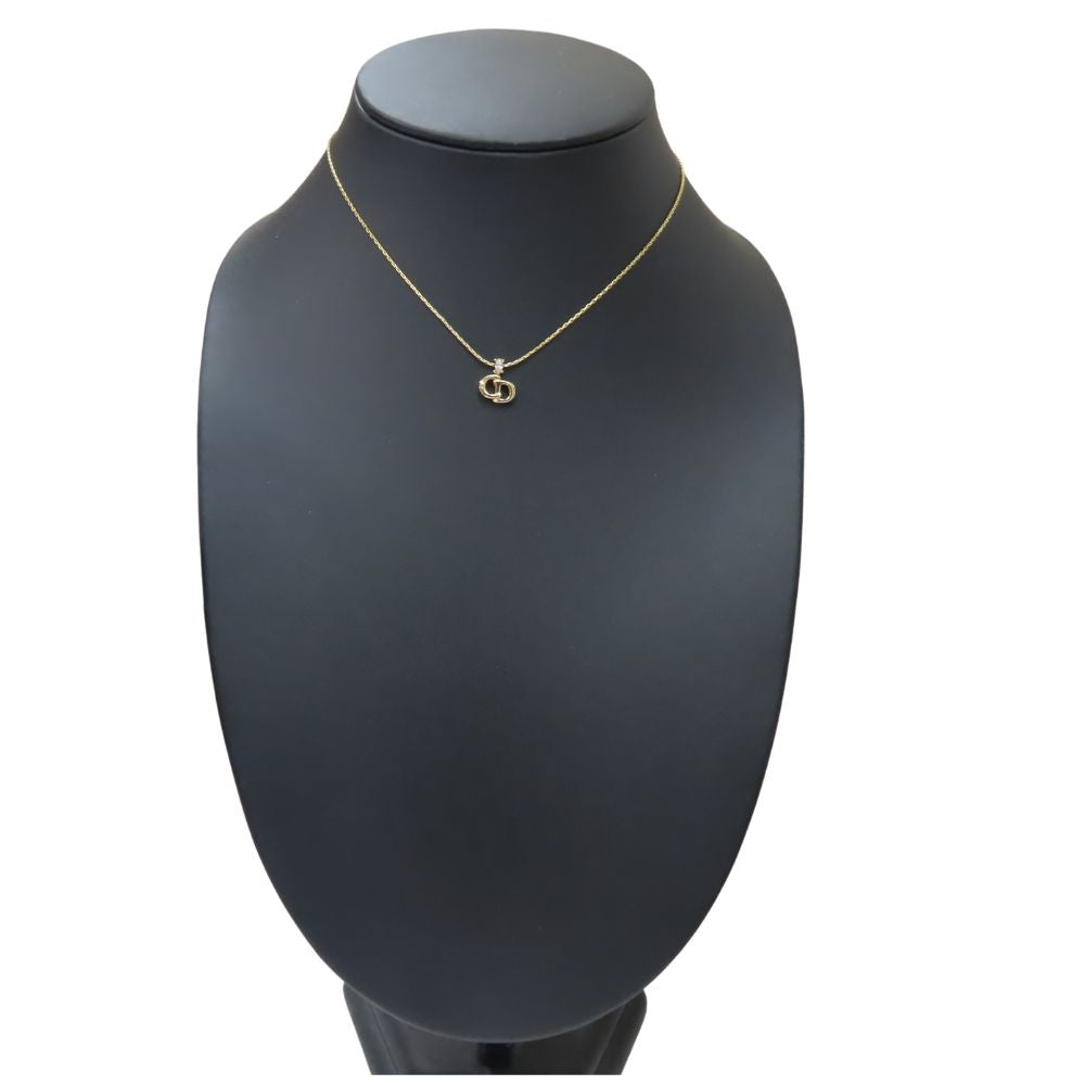 Elegant pre-owned Christian Dior gold necklace displayed on a black bust stand