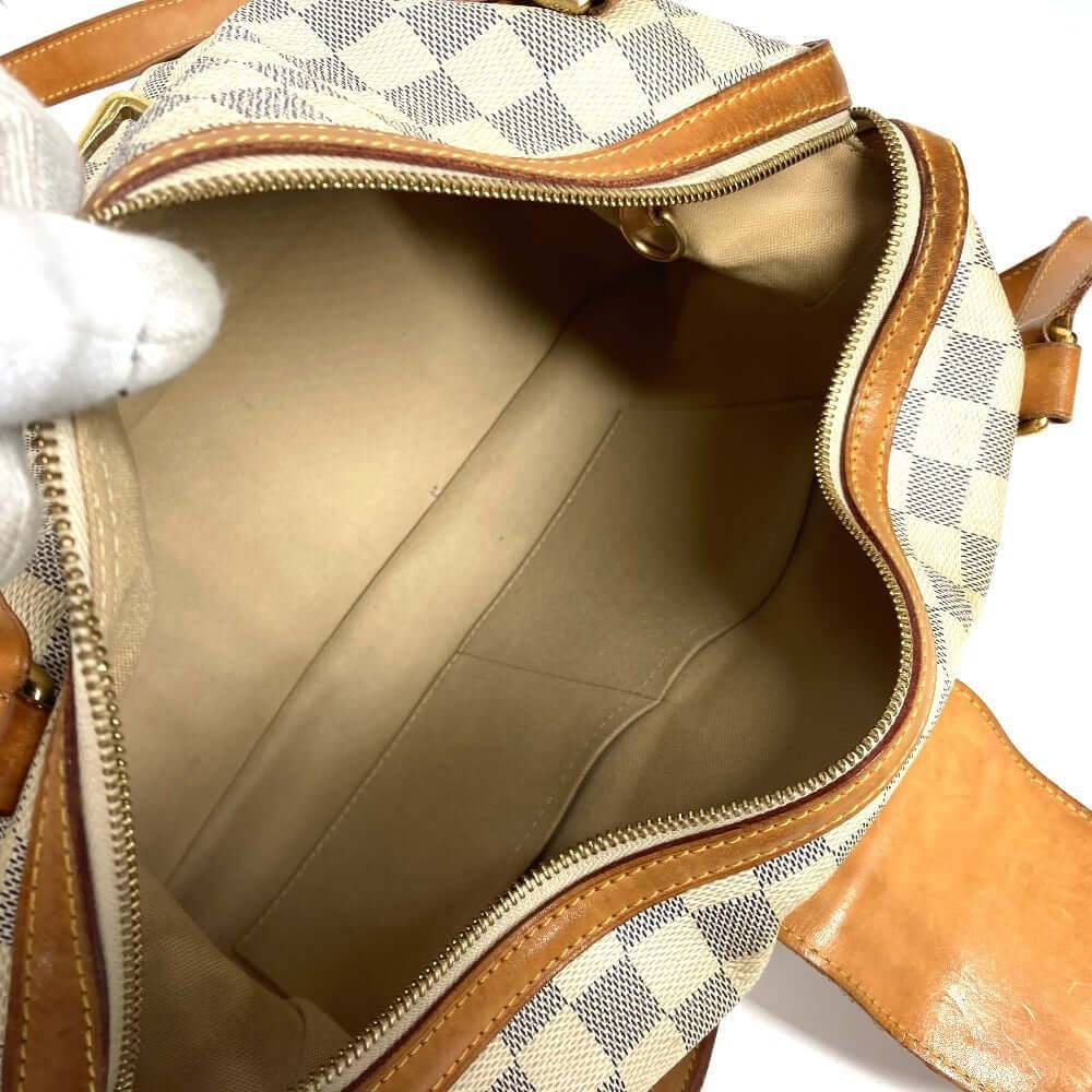 Inside view of a pre-owned Louis Vuitton bag with cream and brown checkered pattern and ample storage space