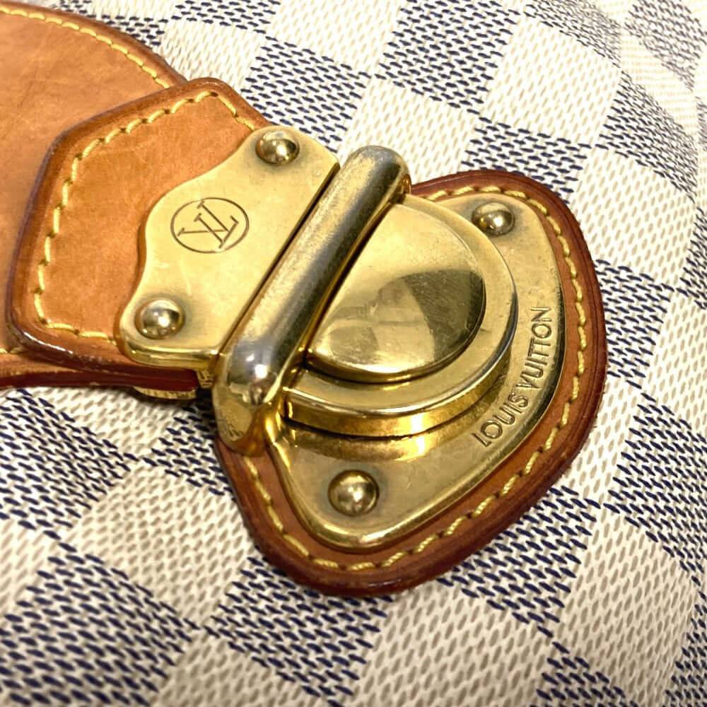 Close-up of LOUIS VUITTON pre-owned bag clasp with gold finish and detailed stitching