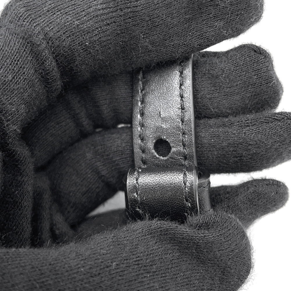 Close-up of MANSII SAINT LAURENT Seria Mini 2 way bag leather strap detail held in a gloved hand