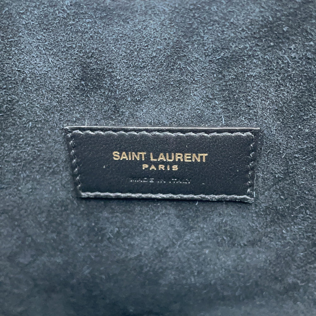 Close-up of SAINT LAURENT Seria Mini 2 way bag logo tag with premium suede texture